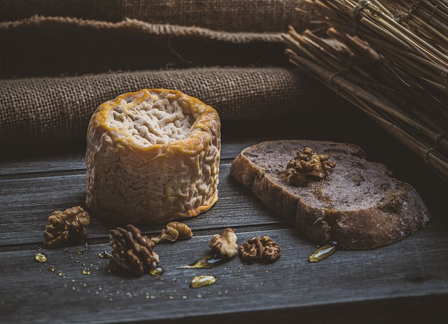 pine cones beside cheese on brown wooden plank, cinnamon bread on brown surface HD wallpaper