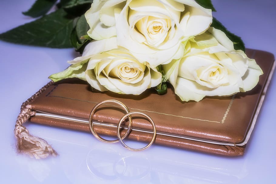 two gold-colored couple ring on book with bouquet, wedding rings, HD wallpaper