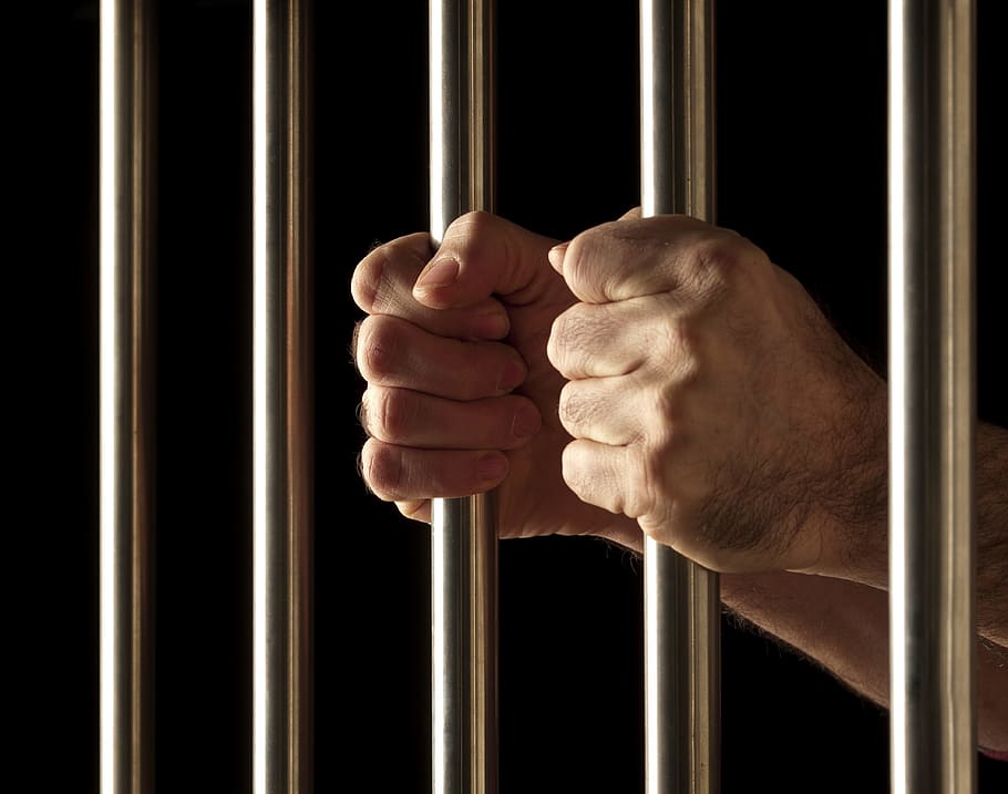 person holding on bars, defense attorney, defense lawyer, criminal defense lawyer