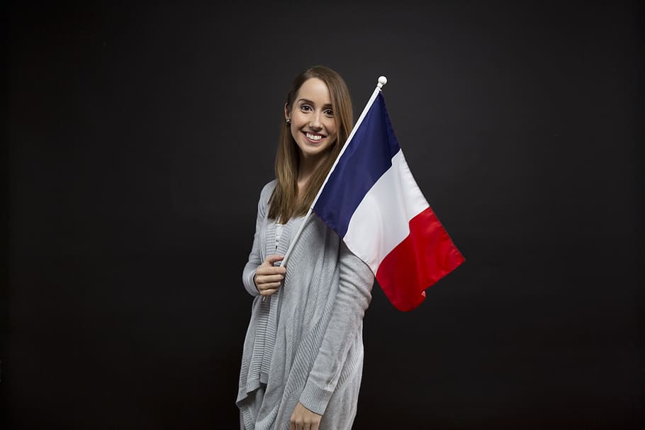 woman wearing gray cardigan holding red, blue, and white flag, HD wallpaper