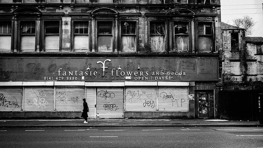 grayscale photo of perso walking on sidewalk, grayscale photo of Fantaste Flowers building HD wallpaper