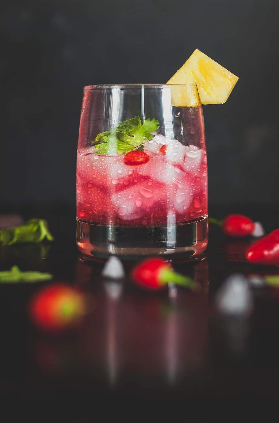 selective focus photography of clear rock glass, cocktail in glass surrounded by chili