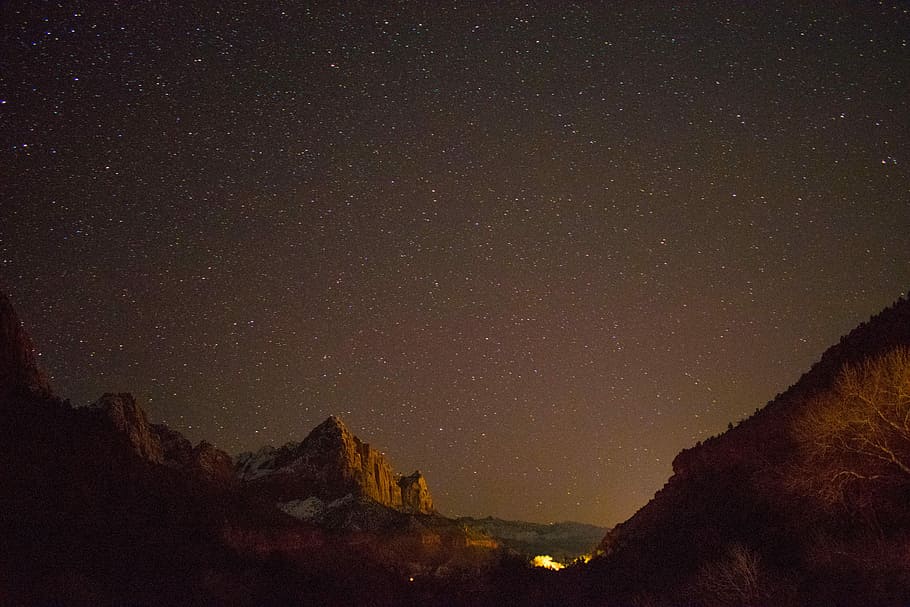 brown rock formation under starry night, brown mountain during nighttime HD wallpaper