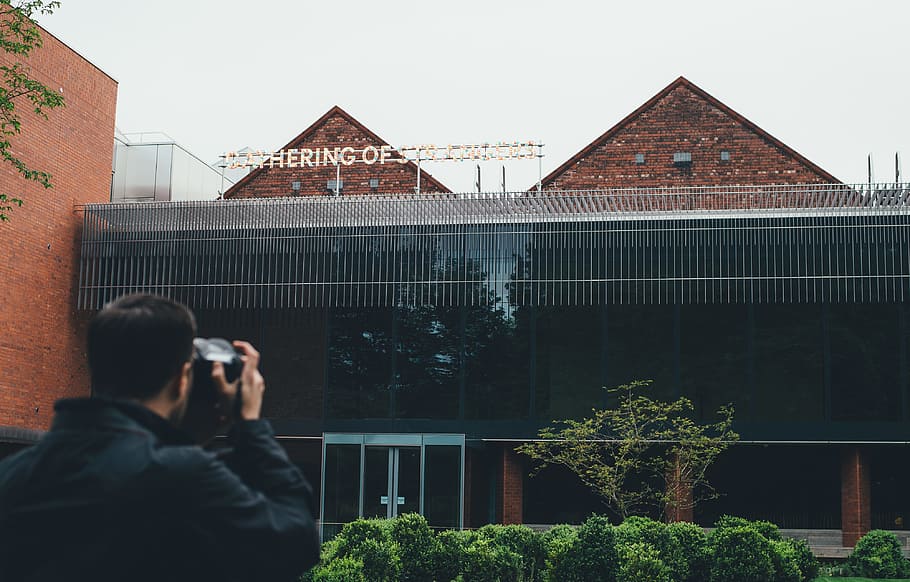 man taking picture to building, man taking photo of brown and black building HD wallpaper