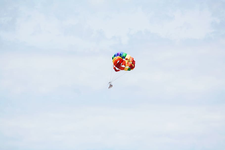 person on parachute sky diving under cumulus clouds, person doing paragliding under cloudy sky HD wallpaper