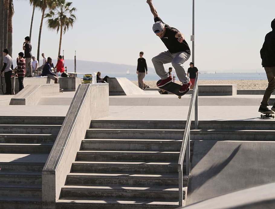 people on gray park with tracks and ramps skateboarding during daytime HD wallpaper
