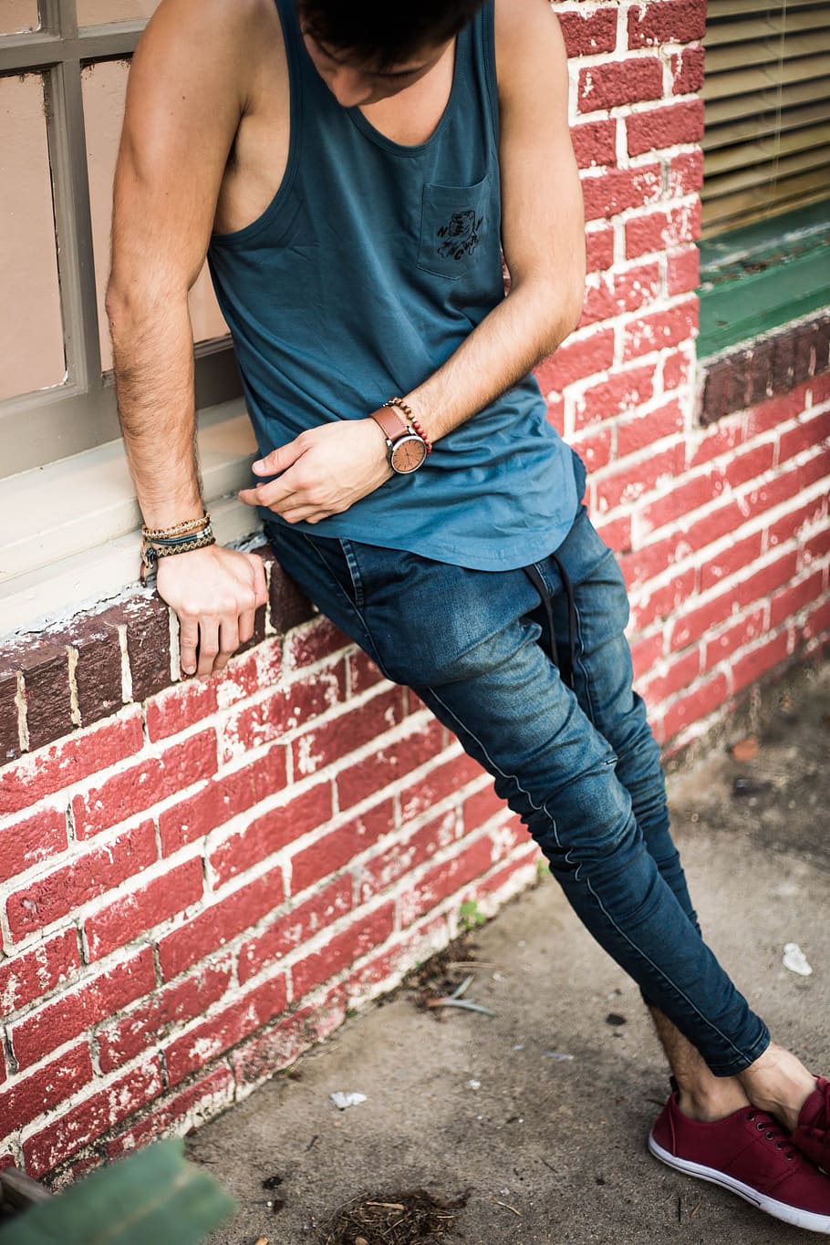 man in blue tank top and blue jeans, man in blue tank top and blue jeans sitting on windowsill