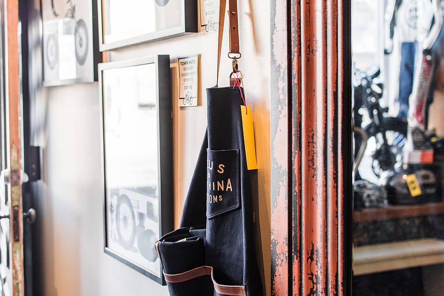 black and brown bag hanged beside wall, black and yellow apron HD wallpaper