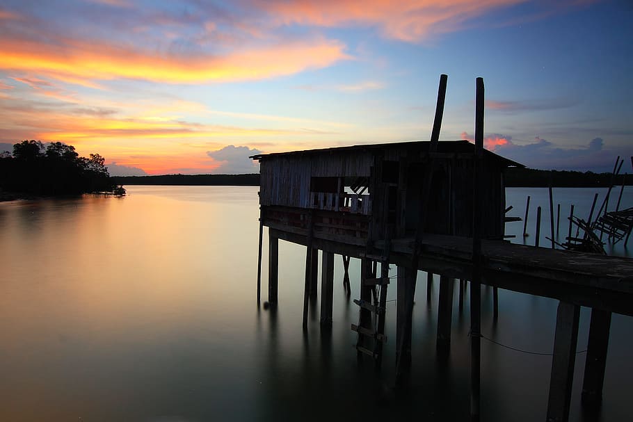 Silhouette of House on Top of Ocean Water during Sunset, backlit HD wallpaper