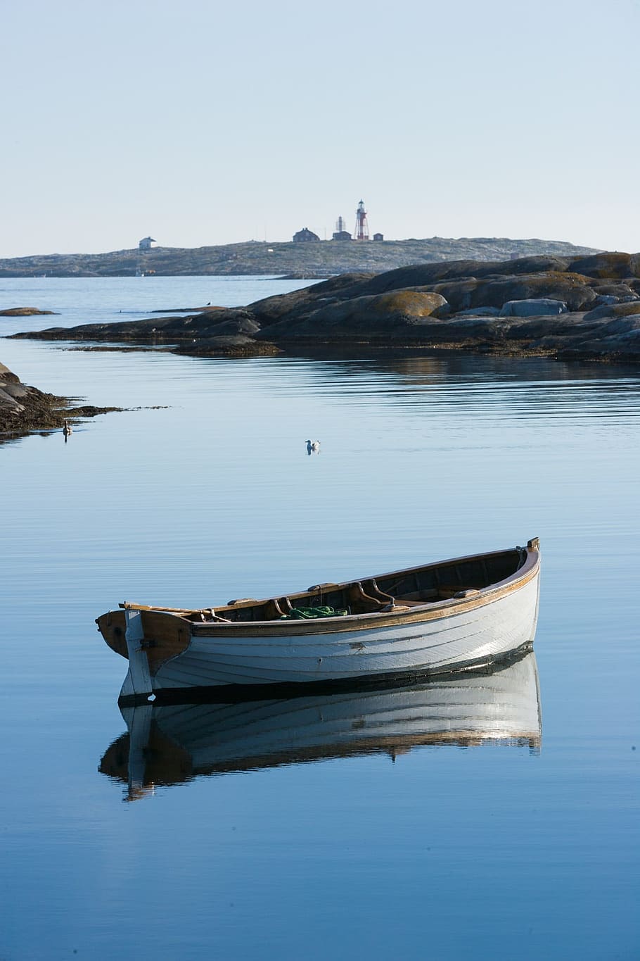 white rowboat on calm body of water under white sky at daytime HD wallpaper