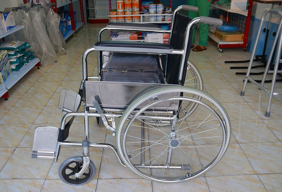 black and silver wheelchair on top of brown ceramic floor tikles