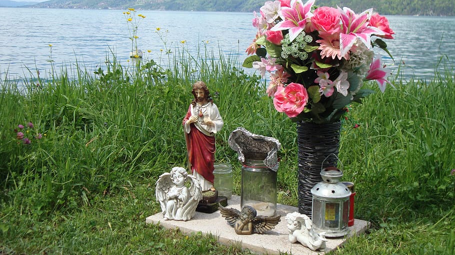 pink rose, lily and daisies in vase beside lantern, Jesus and cherub figurines on grasses HD wallpaper