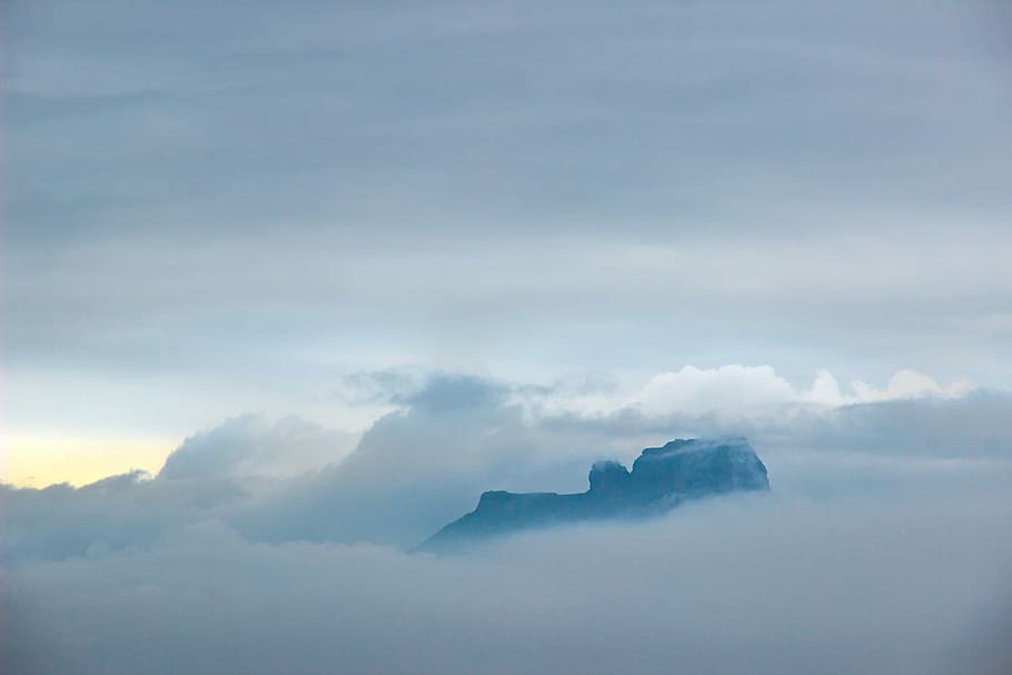 gray plateau with sea of clouds, black rocky mountain surrounded with white clouds HD wallpaper