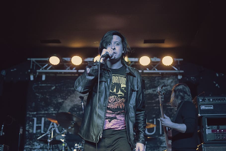 man in black leather jacket singing with microphone, untitled HD wallpaper