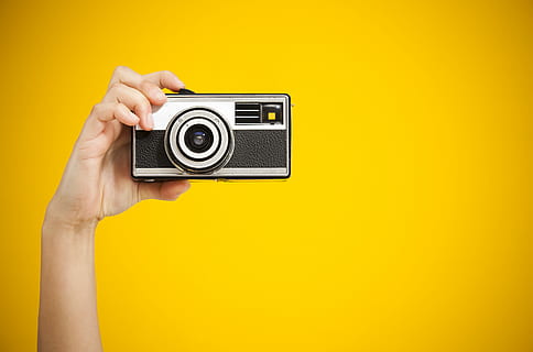 P H O T O G R A P H E R, person holding black and gray camera with yellow background HD wallpaper