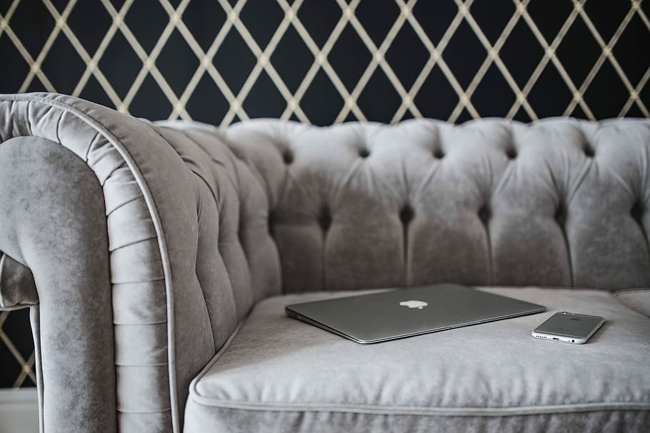 Elegant grey sofa with a laptop, an iPhone and a magazine, furniture