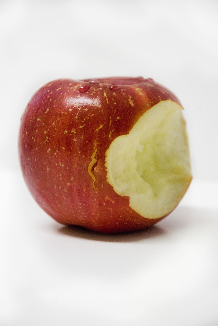 bitten red apple on white tabl, bite, fruit, food, healthy, sweet