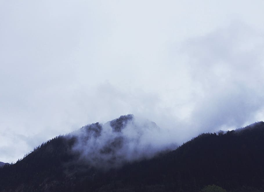 aerial view photography of mountain under white clouds, silhouette photography of mountain covered with mist HD wallpaper