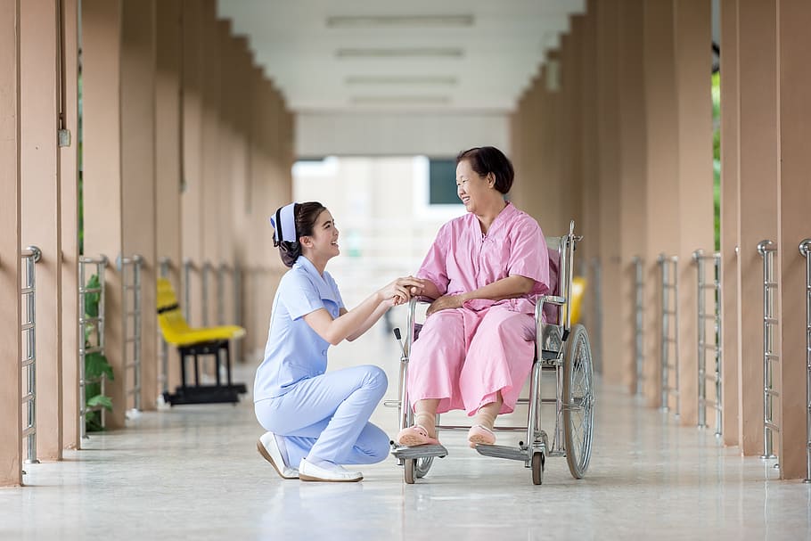 woman in pink dress sitting in wheel chair, hospital, assistance