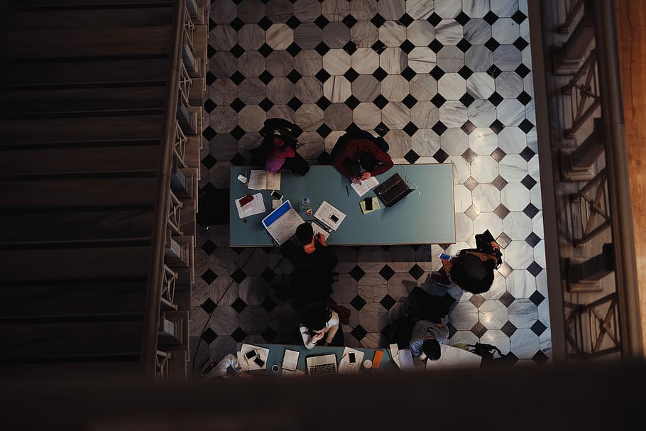photo of group of people inside library, three person sitting beside wooden table HD wallpaper