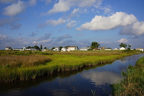 river, town, grass, marshland, clouds, reflection, buildings HD wallpaper