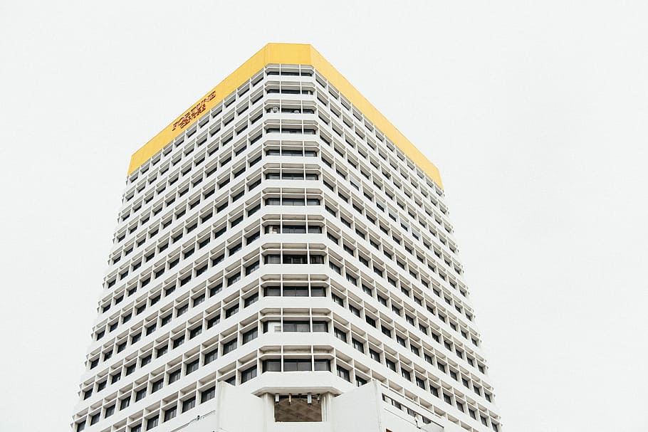 white and yellow tall building under white sky, low-angle photography of white and yellow concrete high-rise building at daytime HD wallpaper