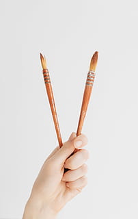 person holding two brown brushes, person holding two brown paint brushes HD wallpaper