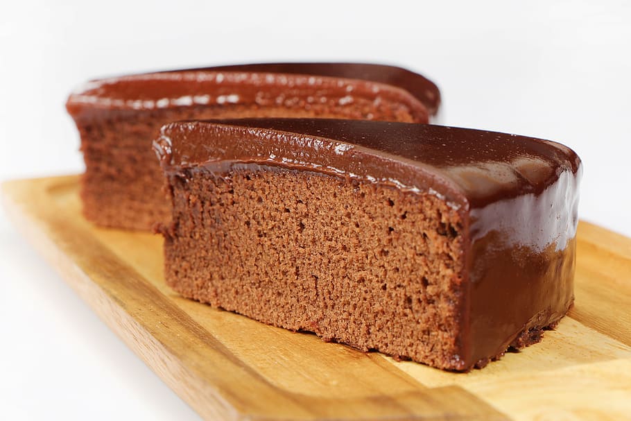 two slices of chocolate cakes on brown wooden board, swede cakes