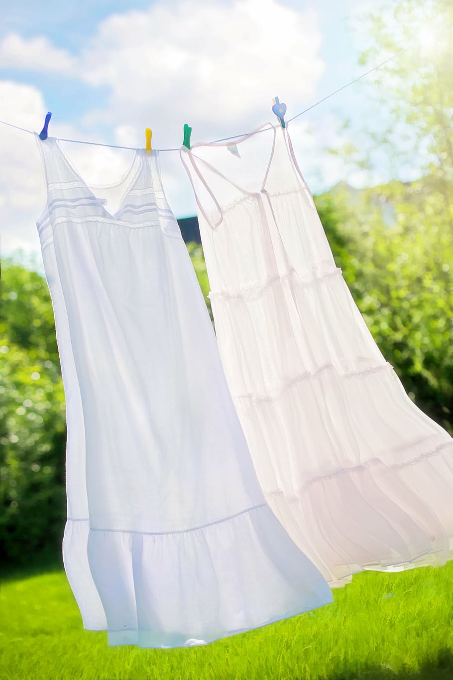 two white long dresses hanged on white rope, clothesline, summer