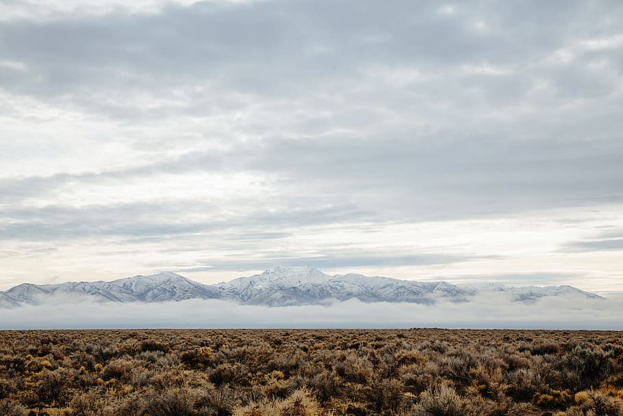 barren field across mountain range photo during cloudy day, brown landscape with blue sky HD wallpaper