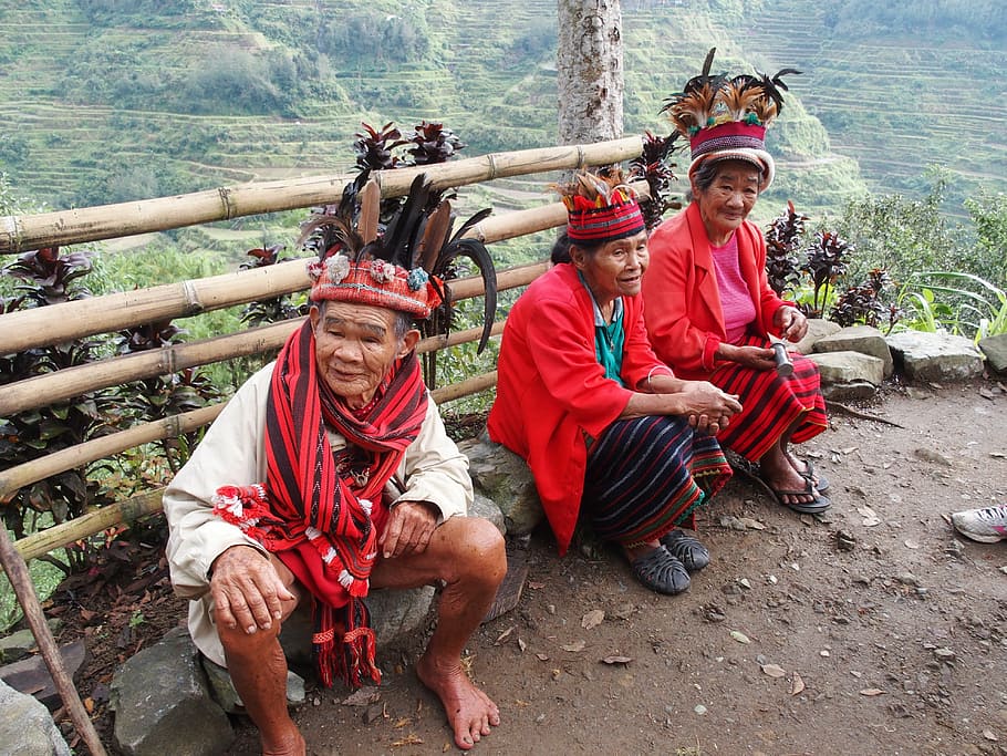 two women and one man sitting on rocks against mountains, philippines HD wallpaper