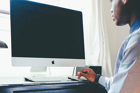 man's hand on silver Apple Track pad infront of silver iMac HD wallpaper