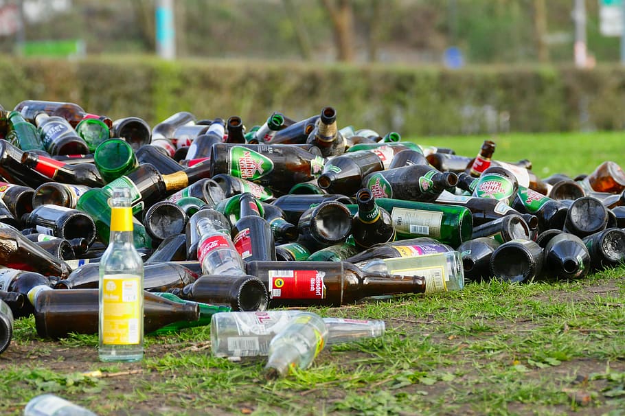 pile of glass bottles on green grass field, waste, garbage, throw away society