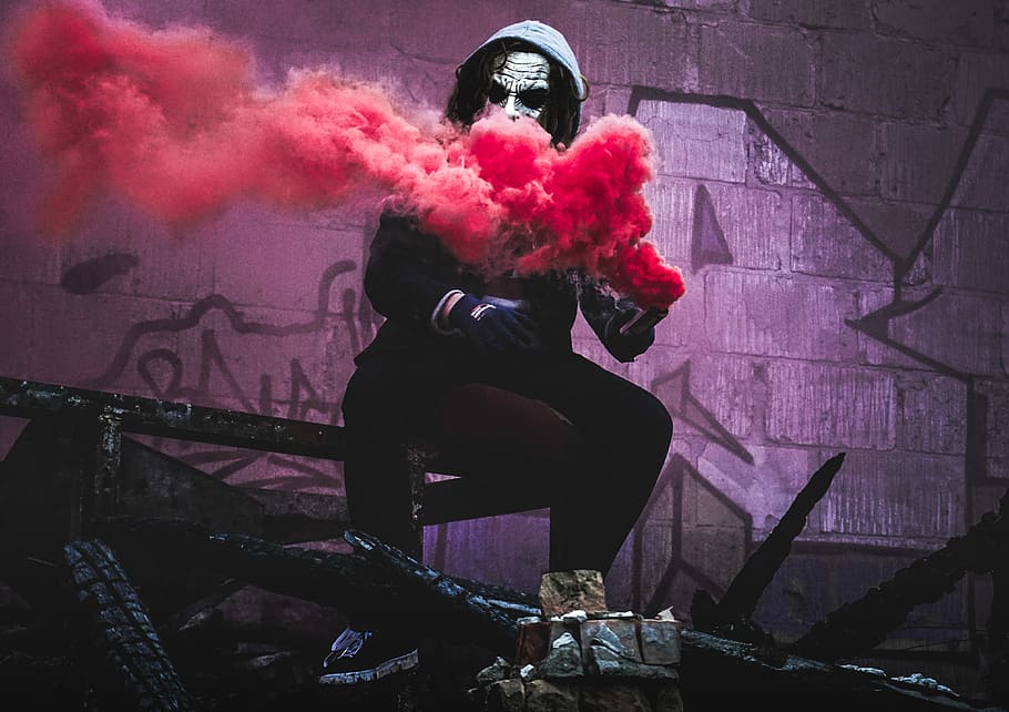 man sitting while holding red smoke signal, person using red smoke sitting on steel bar, HD wallpaper