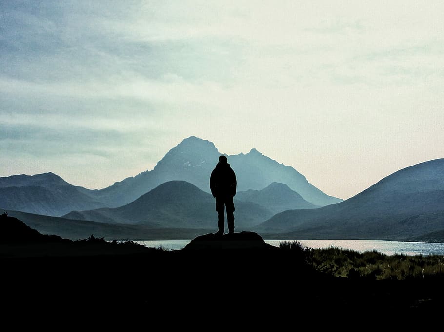 silhouette of man standing on rock near the lake, silhouette man standing on rock facing mountaing HD wallpaper