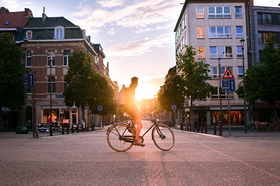 man riding bicycle on road during daytime, man on bicycle on the road during sunset HD wallpaper