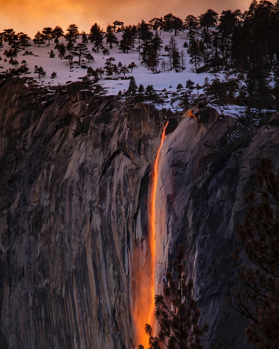waterfalls near cliff at golden hour, brown mountain near trees HD wallpaper