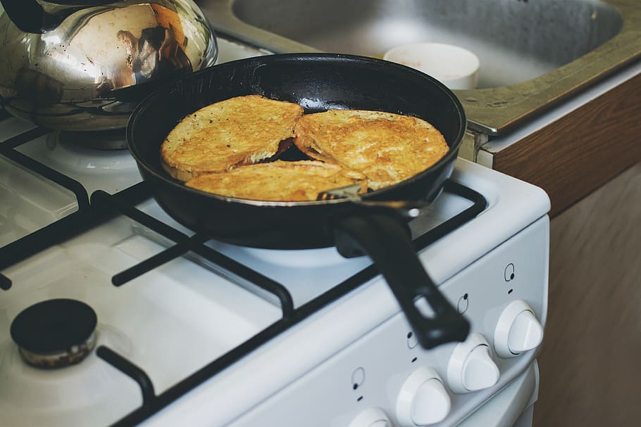 black frying pan on white gas stove, french toast, breakfast