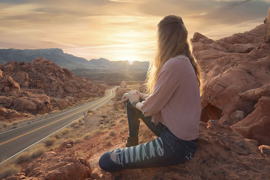 woman in pink long-sleeved shirt and blue denim pants, woman in pink 3/4-sleeved blouse and blue denim distressed jeans sitting in front of road during daytime HD wallpaper