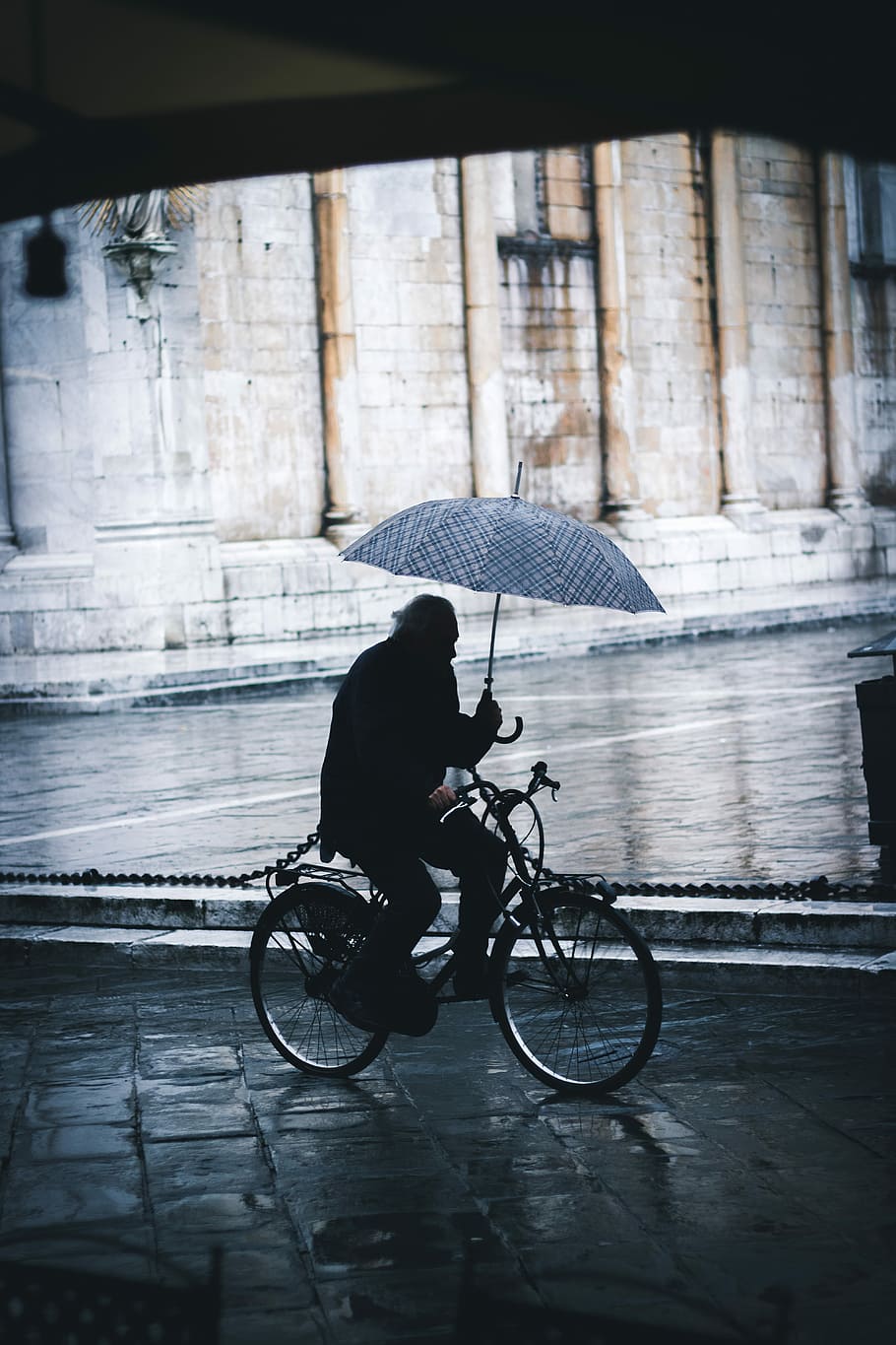 man riding bicycle while holding umbrella near street, person bicycling while holding umbrella near wall, HD wallpaper