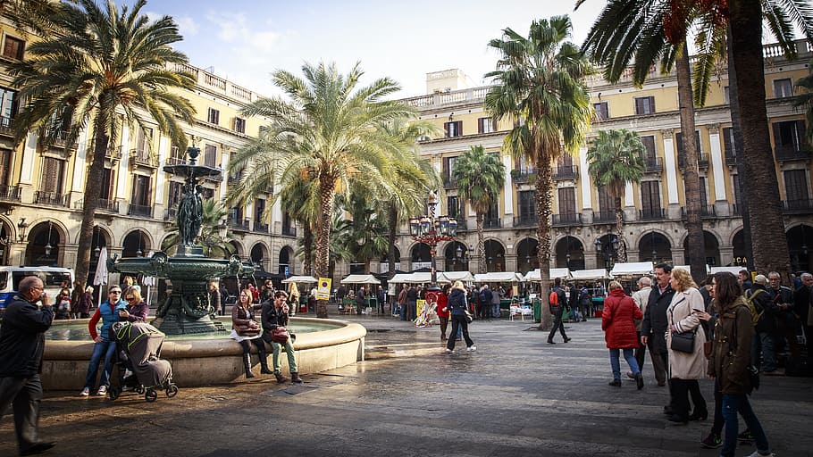 photo of people walking near building and palm trees, Barcelona