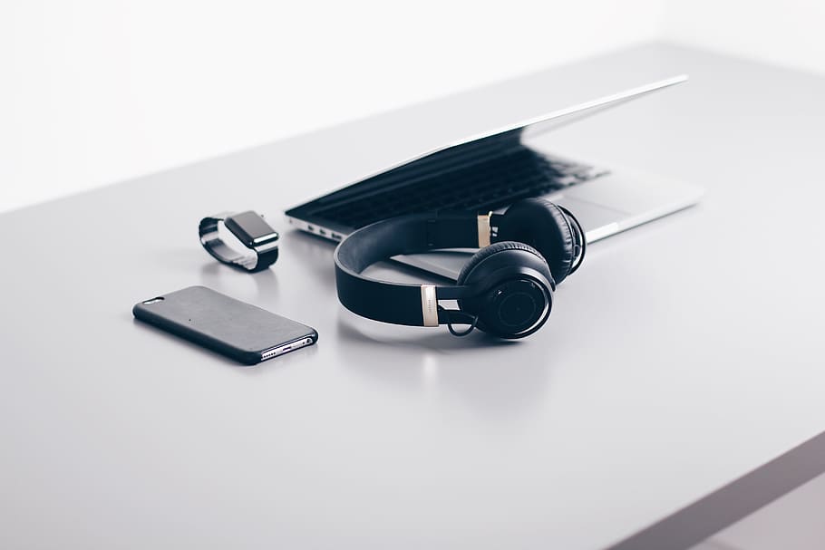 black cordless headphones beside closed black laptop computer and smartphone, black cordless headphones HD wallpaper