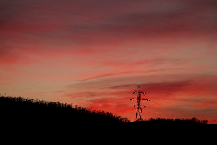 silhouette of light tower near mountain during golden hour HD wallpaper