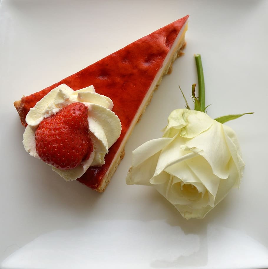 red strawberry on slice pie beside white rose on white surface HD wallpaper