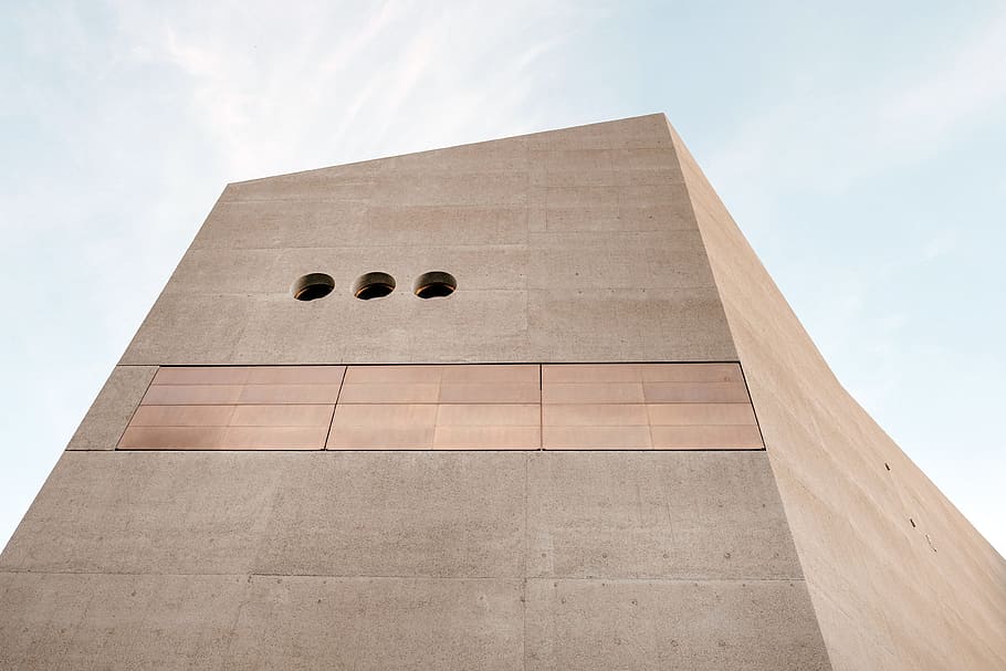 low angle photo of brown concrete building, low angle photo of brown concrete structure under cloudy sky HD wallpaper