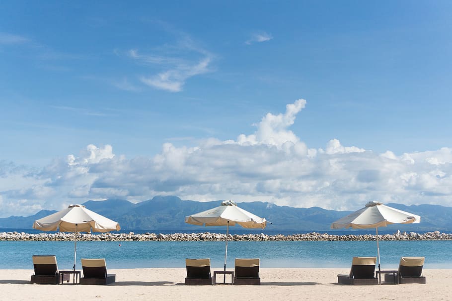 patio umbrella and lounger chair overlooking the sea, three white and black sun lounger with umbrellas facing sea HD wallpaper