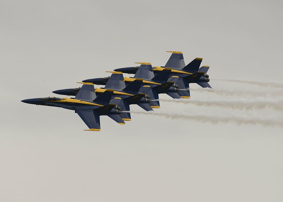 four blue-and-yellow fighter planes flying in the sky during daytime HD wallpaper