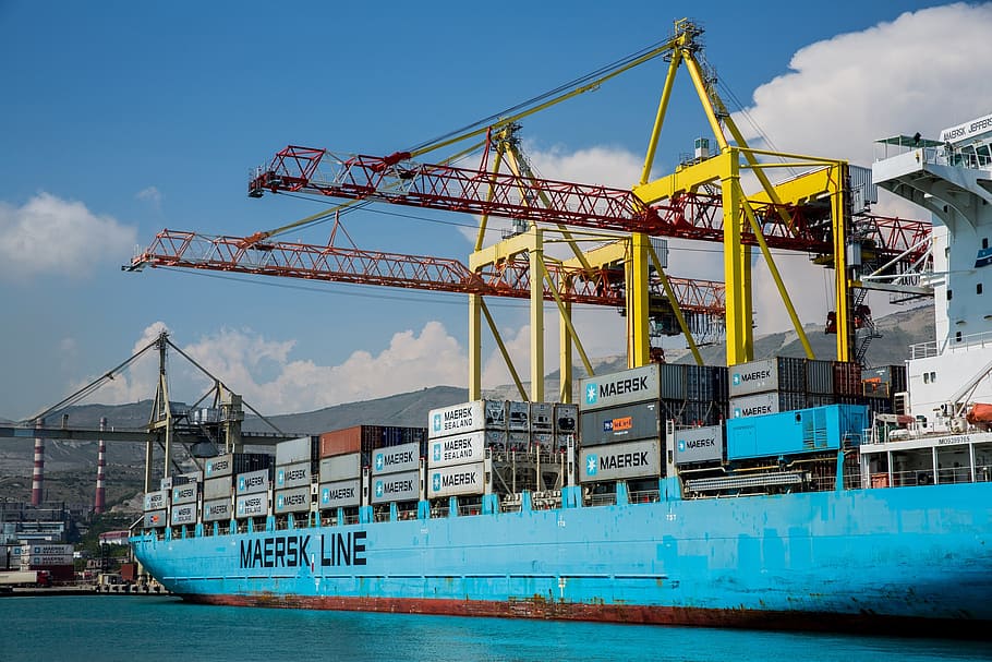 blue Maersk Line ship on body of water, port, crane, load, container