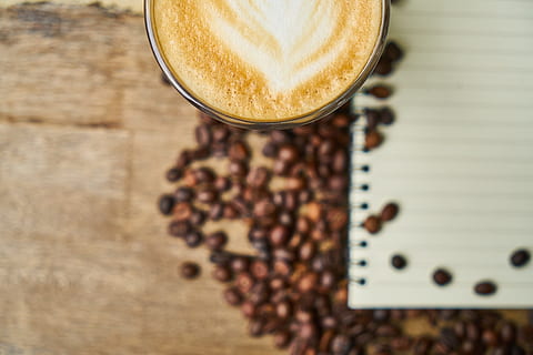 coffee beside white line paper and coffee beans on brown wood surface HD wallpaper