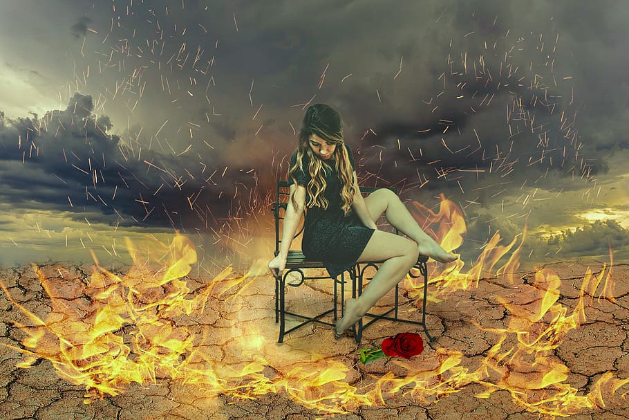 woman sitting on black steel chairs surrounded by fire, fantasy picture